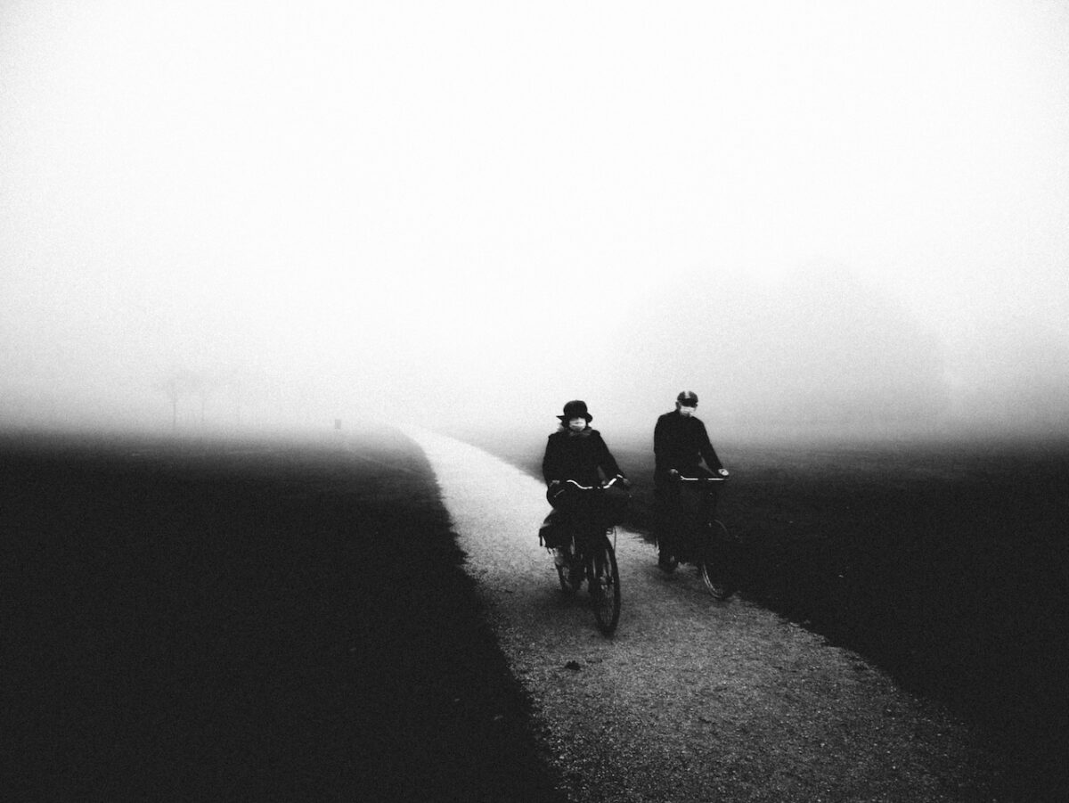 Fotografia di ciclisti nella nebbia